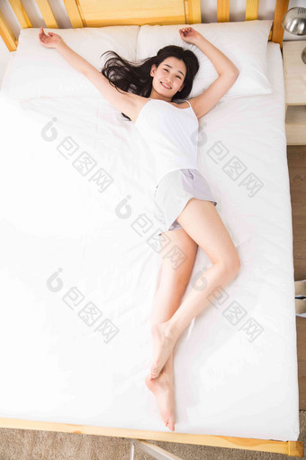青年女人躺在床上张开手臂高端相片