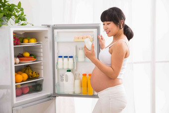 孕妇打开冰箱拿牛奶牛奶高清照片