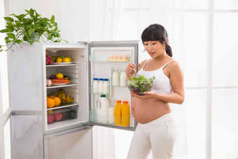 孕妇<strong>打开冰箱</strong>拿蔬菜舒适素材