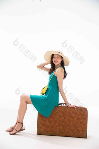 青年女人坐在行李箱上