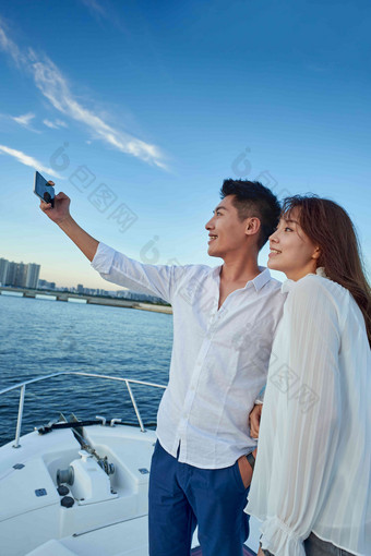 青年夫妇站在游艇上用<strong>手机</strong>拍照视频高质量拍摄