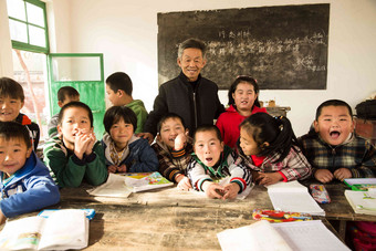 乡村男教师和小学生在教室里团结图片