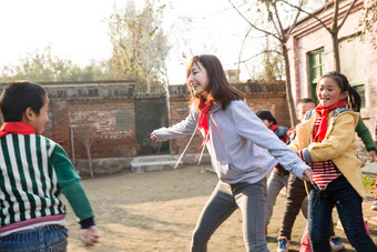 乡村教师和小学生在学校里做游戏