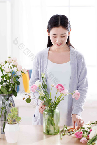 青年女人在闻鲜花的香味起居室高端摄影
