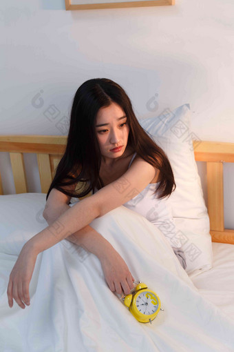 情绪低落的青年女人坐在卧室的床上