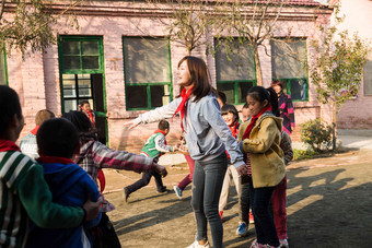 乡村教师和小学生在学校里做游戏