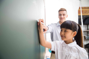 老师在指导小学生学习关爱写实拍摄