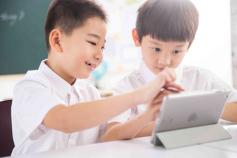 两个小学生在使用平板电脑摄影氛围摄影图