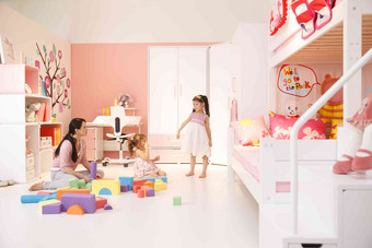 两个小女孩和妈妈在卧室玩耍