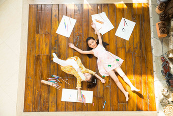 姐妹俩躺在地板上玩耍东方人氛围素材
