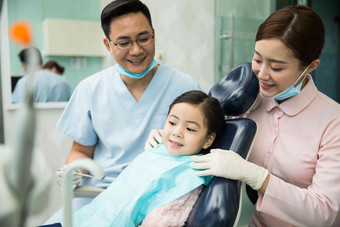 男牙医和女牙医助手在为小女孩检查牙齿卫生保健和医疗高端影相