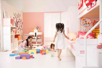 青年女人和两个女孩在卧室玩耍相伴场景