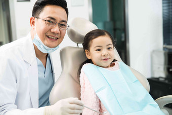 男牙医在为小女孩检查牙齿牙科诊疗室清晰图片