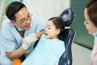 男牙医和女牙医助手在为小女孩检查牙齿口腔卫生高清摄影