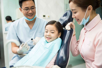 男牙医和女牙医助手在为小女孩检查牙齿专门技术写实镜头