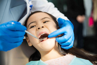男牙医在为小女孩检查牙齿