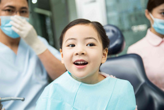 男牙医和女牙医助手在为小女孩检查牙齿服务高清相片
