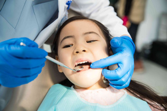 男牙医在为小女孩检查牙齿仔细检查拍摄
