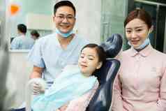 男牙医和女牙医助手在为小女孩检查牙齿