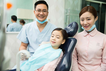 男牙医和女牙医助手在为小女孩检查牙齿三个人清晰照片