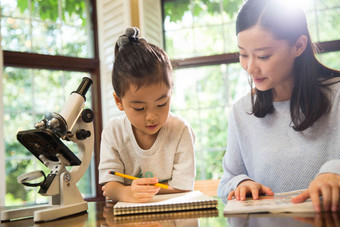 妈妈辅导女儿做作业写字氛围摄影图