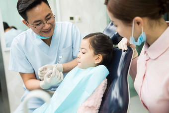 男牙医和女牙医助手在为小女孩检查牙齿服务氛围相片