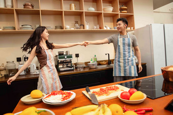 青年夫妇在家边做饭边跳舞家务写实拍摄