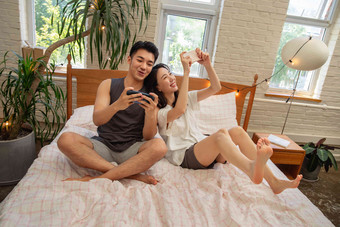 <strong>青年</strong>情侣趴在床上玩手机