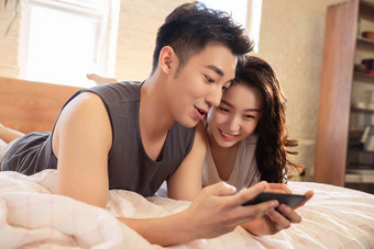 青年手机趴着卧室青年伴侣写实影相