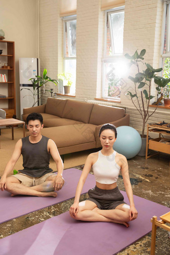 青年夫妇在家做瑜伽