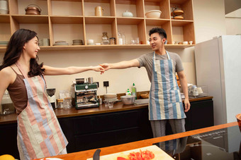 青年夫妇在家边做饭边跳舞蔬菜场景