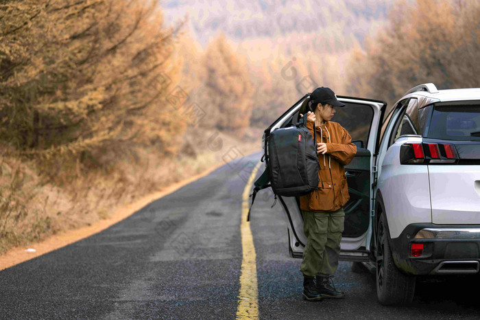 徒步旅行的年轻女子搭车季节高质量照片