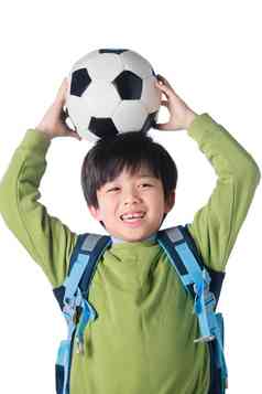 一个男孩把足球放在头顶