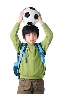 一个男孩把足球放在头顶