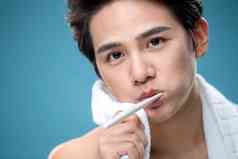 年轻男人用毛巾擦刷牙时脸上的泡沫