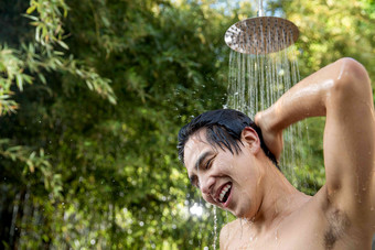 年轻男人在户外淋浴洗头