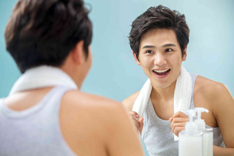 快乐的年轻男人拿着毛巾照镜子满意氛围图片
