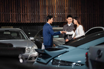 汽车销售人员和青年<strong>夫妇握手</strong>协助清晰相片