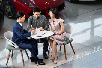 汽车销售人员与青年夫妇确认购车意向销售氛围素材