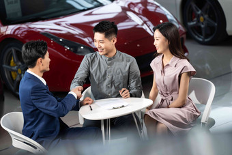 汽车销售人员与青年夫妇握手售货员清晰素材