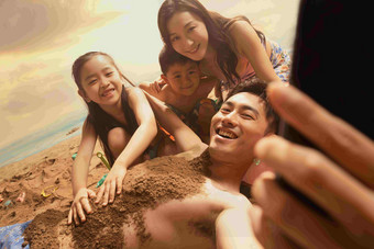 沙滩上男人拿手机和妻子孩子自拍<strong>愉悦</strong>高端拍摄