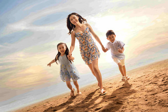 <strong>年轻母亲牵</strong>着两个孩子在沙滩上奔跑