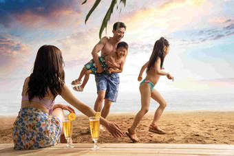 幸福的四口之家在沙滩上享受休闲时光