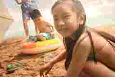 可爱的东方儿童在沙滩上玩耍