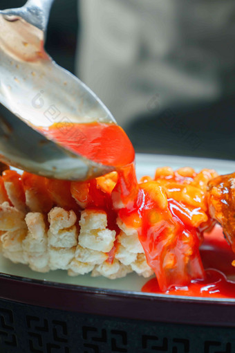 番茄酱浇在鱼身炒菜勺高质量摄影图