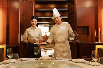 酒店厨师服务员上菜并介绍烹饪氛围摄影图