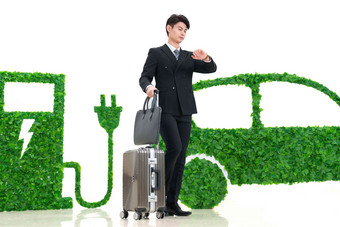青年男士推着行李箱走在电动汽车旁商务旅行高端图片