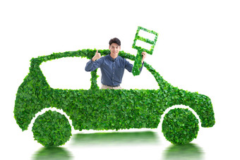 青年男人驾驶绿色环保汽车出行