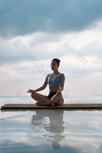 年轻女人在<strong>水面</strong>上练习瑜伽