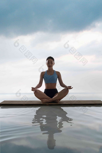 年轻女人在<strong>水面</strong>上练习瑜伽